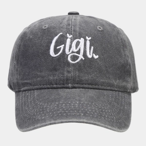 Detail of white Gigi cursive embroidery on dark gray washed cotton baseball cap