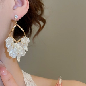 Detail of white petal tassel earrings with gold twisted frame and sparkling zircon stud