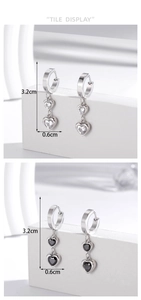 Detailed size view of vertical heart-shaped stud earrings in black and white zirconia