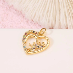Detail view of a 14K gold heart pendant with colorful zircon stones on a white surface