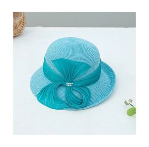 Détail d'un chapeau de paille bleu sarcelle avec un grand nœud et des perles élégantes