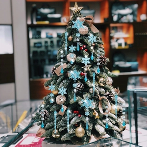 Miniature Christmas tree with blue snowflakes, icicles, gold stars and natural pinecones