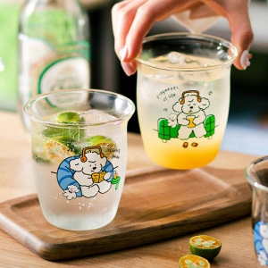 Close-up of glass cups with cute white cartoon dog prints filled with refreshing cold drinks