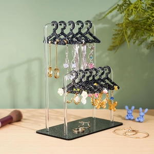 Macro view of clear acrylic earring organizer with glittery mini clothes hangers