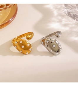 Detail of gold and silver fluid rings with white pearl inlays on a minimalist background
