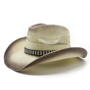 Détail d'un chapeau de cowboy en paille tressée avec clous argentés et motif ajouré aéré