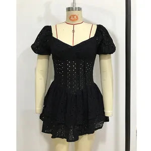 Detalle de tela de algodón Broderie Anglaise negra en un vestido de mangas abullonadas