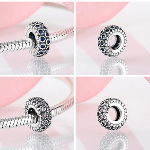 Macro detail of S925 sterling silver charms with blue and pink pavé zircon stones