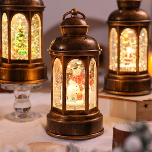 Close-up of three vintage bronze Christmas lanterns with glowing snow globe scenes inside