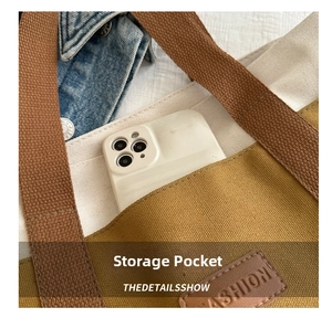 Detail of the brown canvas front pocket with FASHION leather patch on the tote bag