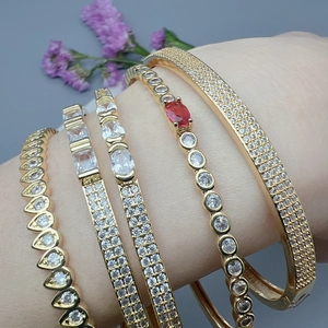 Golden geometric zircon bracelet set featuring elegant red gemstones and stacked layers