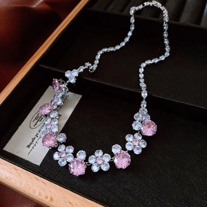 Macro detail of vintage floral necklace with pink zircon and crystals in a velvet box
