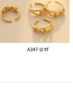 Close-up of gold-plated twisted rings with white shell inlay on a ceramic plate