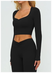 Détail de l'ensemble de yoga noir avec col en cœur et haut court à manches longues