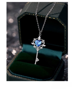 Macro shot of S925 silver key necklace with blue heart gemstone in velvet box