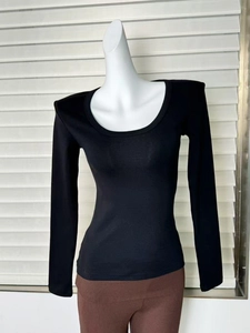 Dettaglio della maglia nera a maniche lunghe con scollo a U e trama in maglia fine