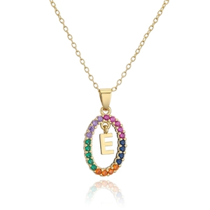 Macro detail of gold letter E necklace pendant with rainbow zircon stones on white background
