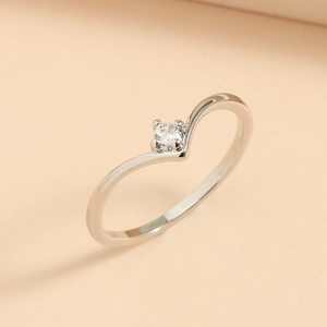 Macro side view of polished silver V-shaped ring with a sparkling round white zircon