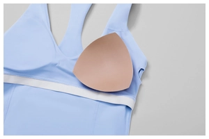 Detail view of removable nude sponge chest pads and white elastic band of yoga bra
