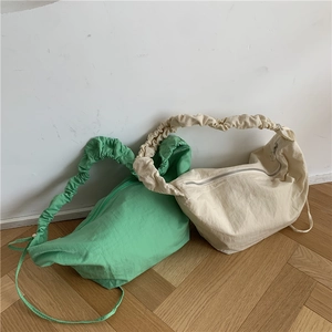 Dettaglio di borse in nylon verde e crema con spalline decorative in stile scrunchie