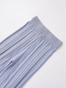 Close-up of light purple knitted texture and elastic waistband with hollow-out design