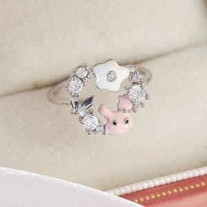 Detail of silver floral ring with pink rabbit charm and sparkling cubic zirconia stones