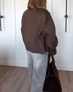 Vue arrière d'un mannequin portant une veste courte marron ample et un jean gris