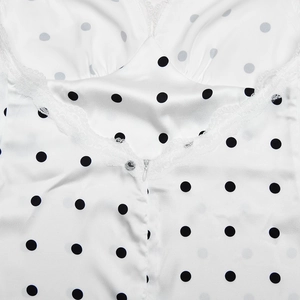 Dettaglio vestito in raso a pois con bordo in pizzo bianco e cerniera invisibile sul retro