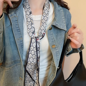 Detail of paisley print silk scarf necklace on model wearing denim jacket and white top