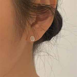 Close-up of a minimalist S925 silver rectangle stud earring with sparkling zircons on ear