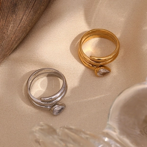 Detailed view of double layered gold and silver snake rings with pear cut white zircons