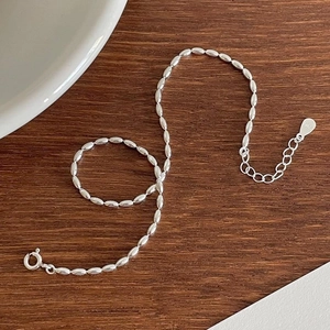 S925 sterling silver olive bead anklet with adjustable chain on wooden surface