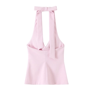 Close-up of pink halter neck top featuring a decorative bow tie on the neckline