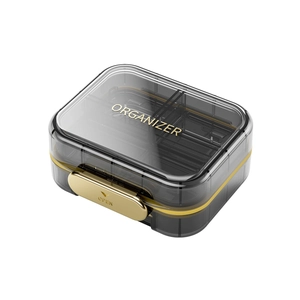 Portable 7-day pill organizer box with gold latch and semi-transparent smoky gray cover