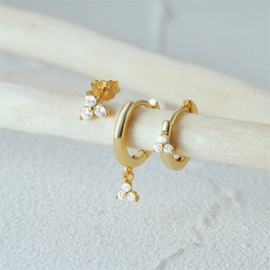 Macro shot of gold plated S925 sterling silver earrings with triple zircon studs