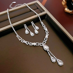 Detailed view of silver teardrop diamond necklace and earrings set in a premium box