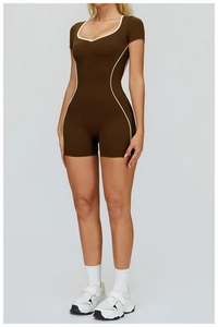 Detailed view of deep brown athletic romper with white contrast trim and U-neckline