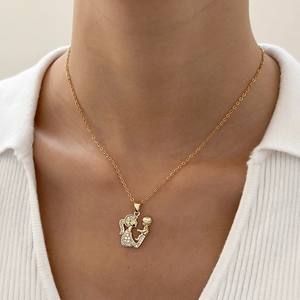 Golden necklace with mother and child embrace pendant worn on model for Mother's Day