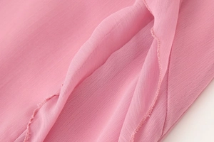 Détail du tissu rose semi-transparent avec texture respirante et coutures fines