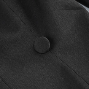 Macro detail of a black fabric covered button on a twill woven blazer bodysuit