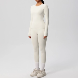Détail du tissu brossé sur le haut de yoga à manches longues crème et le legging haut