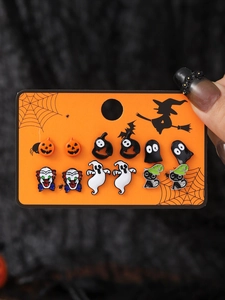 Close-up of Halloween earring set with pumpkin, ghost and clown designs on card
