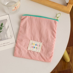 Pink nylon cosmetic pouch with mint green zipper for makeup and lipstick storage