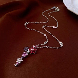 Macro view of zircon flower tassel necklace with colorful gems on velvet background
