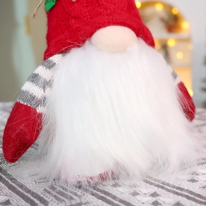 Close-up of a festive Christmas gnome with a red knitted hat and warm glowing LED lights