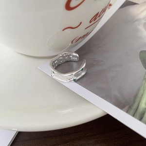 Irregular S925 sterling silver ring featuring a small green gemstone and wavy edges