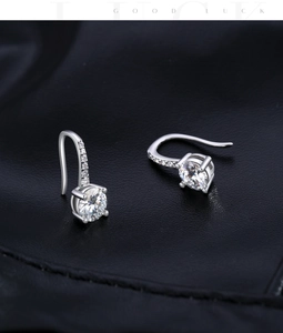 Macro shot of 925 sterling silver drop earrings with 1 carat round moissanite and four prongs