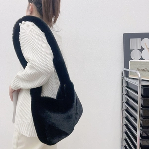 Chic black faux fur shoulder bag worn by model, showing soft texture and large tote capacity