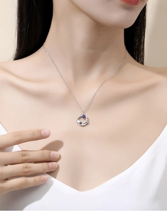 Detail of S925 sterling silver necklace with blue star pendant worn by a model