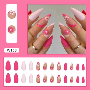 Detail of pink stiletto press-on nails with floral 3D accents and gold glitter lines